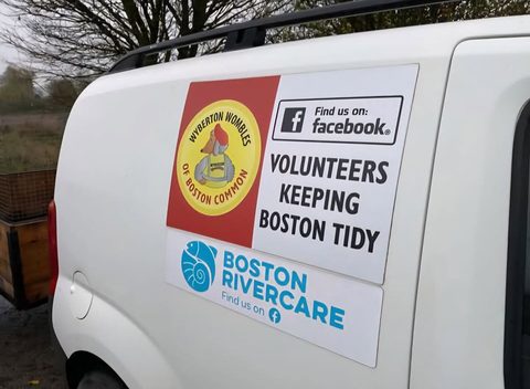 The side of a white van with a Wyberton Wombles of Boston Common sticker reading Volunteers keeping Boston tidy, and a Boston Rivercare sticker below it